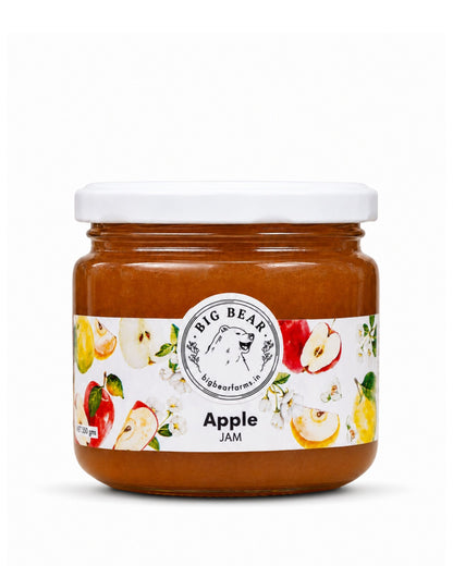 A jar of Big Bear Farms Apple Jam with a white lid and a white label decorated with illustrations of apples and flowers, set against a plain white background.