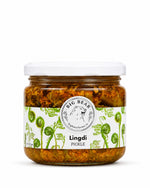 A glass jar of Big Bear Farms Lingdi Pickle (fiddlehead fern pickle) with a white lid and a white label decorated with green illustrations of lingdi, set against a plain white background.