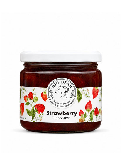 A jar of Big Bear Farms Strawberry Preserve with a white lid and a white label decorated with illustrations of strawberries and green leaves, set against a plain white background.