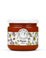 A jar of Big Bear Farms Thyme Honey on a clean white background. The jar contains amber-colored honey and features a white lid and a decorative label with illustrations of bees, flowers, and herbs.