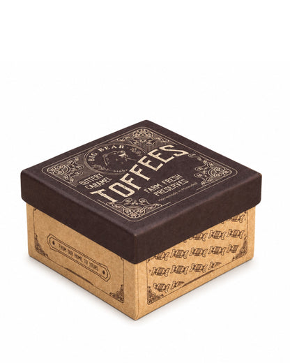 A square cardboard box of Big Bear Farms Buttery Caramel Toffees, featuring a dark brown lid with gold lettering and a brown kraft cardboard base, shown on a white background.